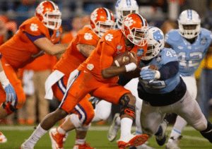 Clemson's DeShaun Watson attempts to run through a North Carolina defender. Photo via tackleo.com.