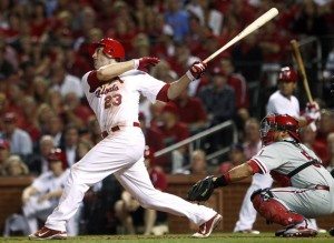 St. Louis Cardinals' David Freese (L) hits a two-run home run as Philadelphia Phillies' catcher Carlos Ruiz looks on during the sixth inning of Game 4 of their MLB National League Divisional Series baseball playoffs in St. Louis October 5, 2011. REUTERS/Sarah Conard (UNITED STATES - Tags: SPORT BASEBALL)